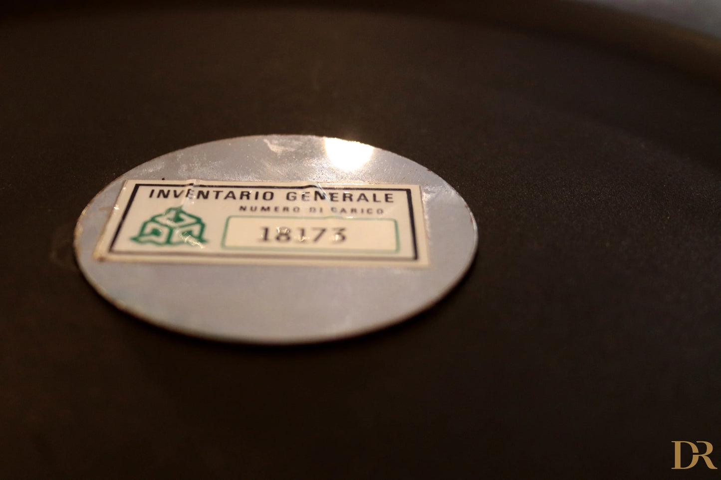 Etichetta di inventario ovale argento con testo verde e nero su appendiabiti velca paolo orlandini e velca milano